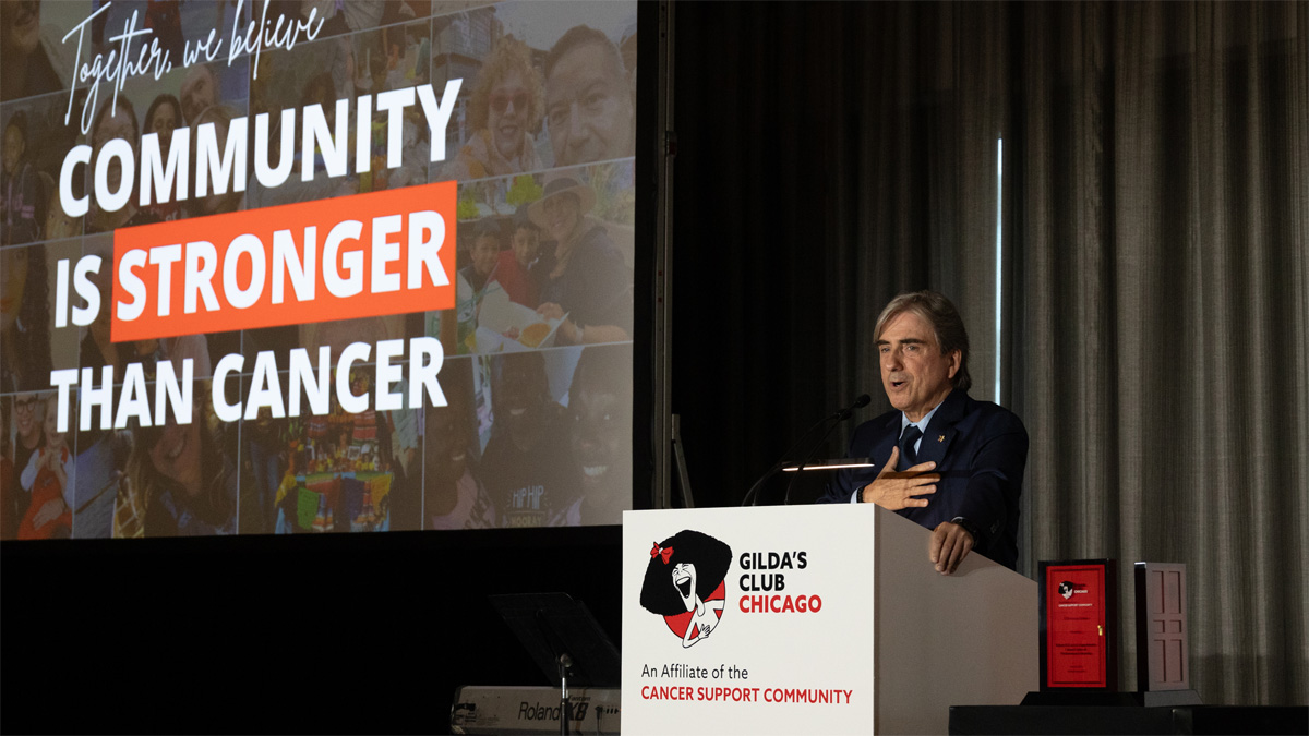 Leonidas Platanias speaks from behind a podium at a Gilda's Club event