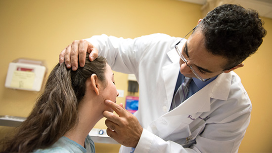 Doctor examines moles on a patients face
